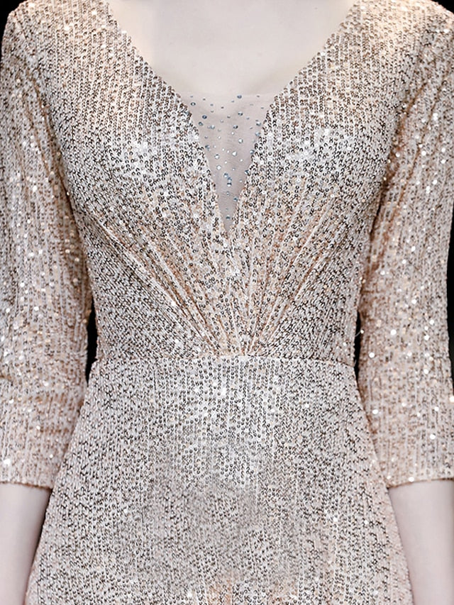 Back view of a woman in a sparkling A-line V-neck prom dress, showing the elegant drape of the floor-length skirt.