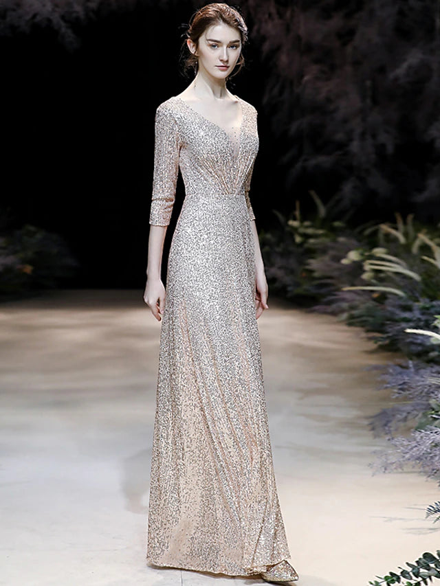 Woman posing in a sparkling A-line V-neck prom dress, showcasing the full silhouette.