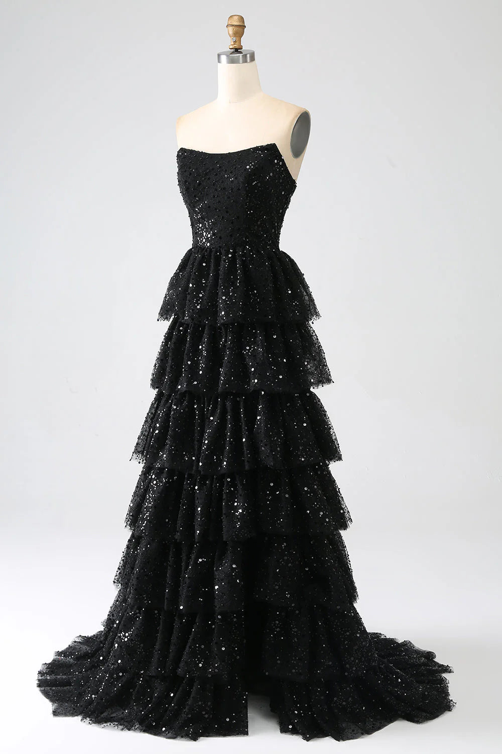 Detail of tiered skirt and high slit on black sequin prom dress.