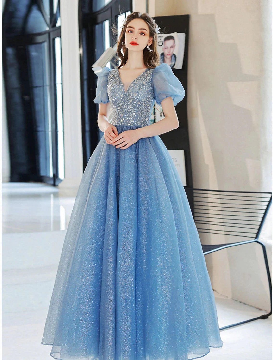 Woman wearing a sparkling A-line V-neck floral ball gown with short sleeves and floor length.