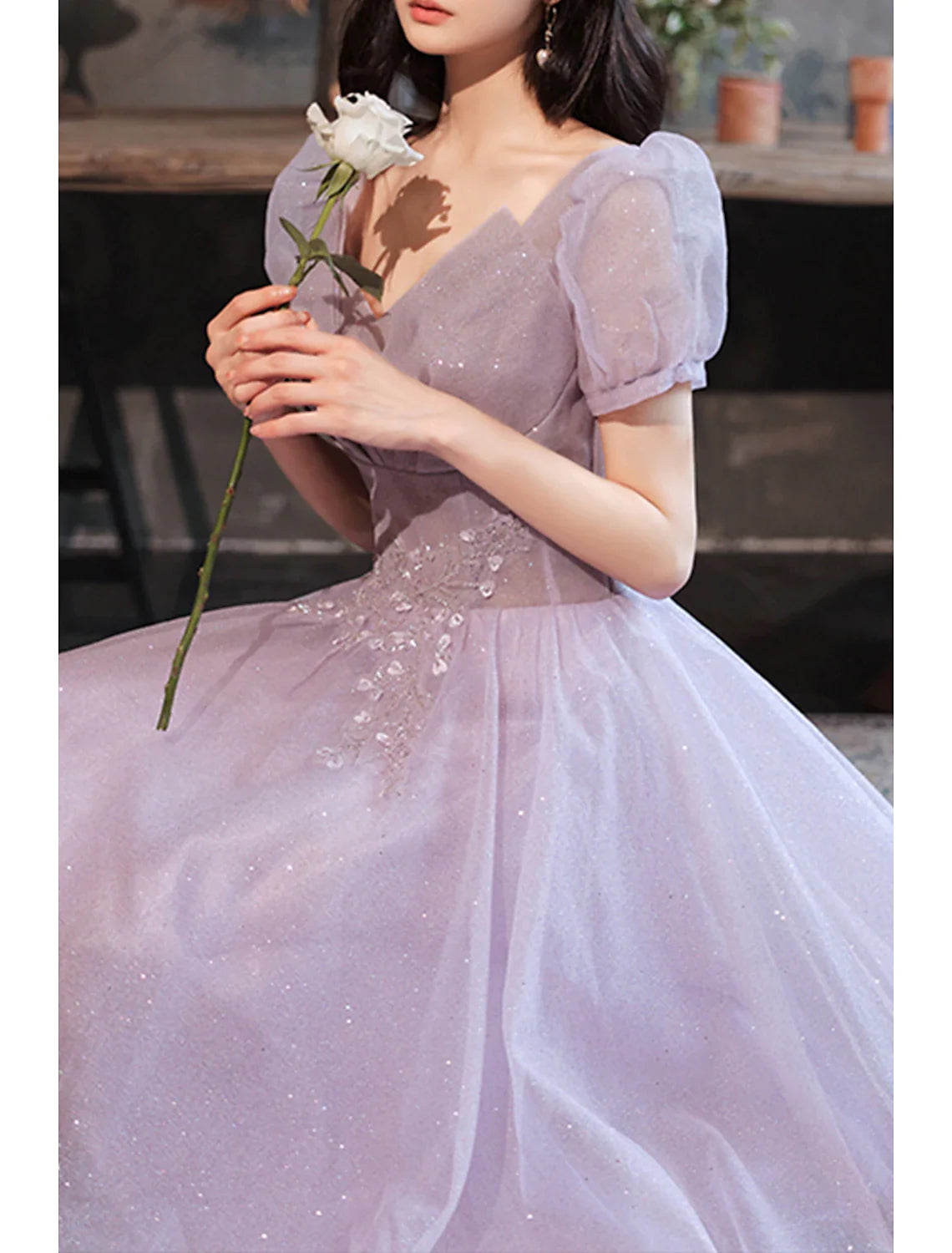 Side view of a model showcasing the A-line silhouette of the sequin dress.