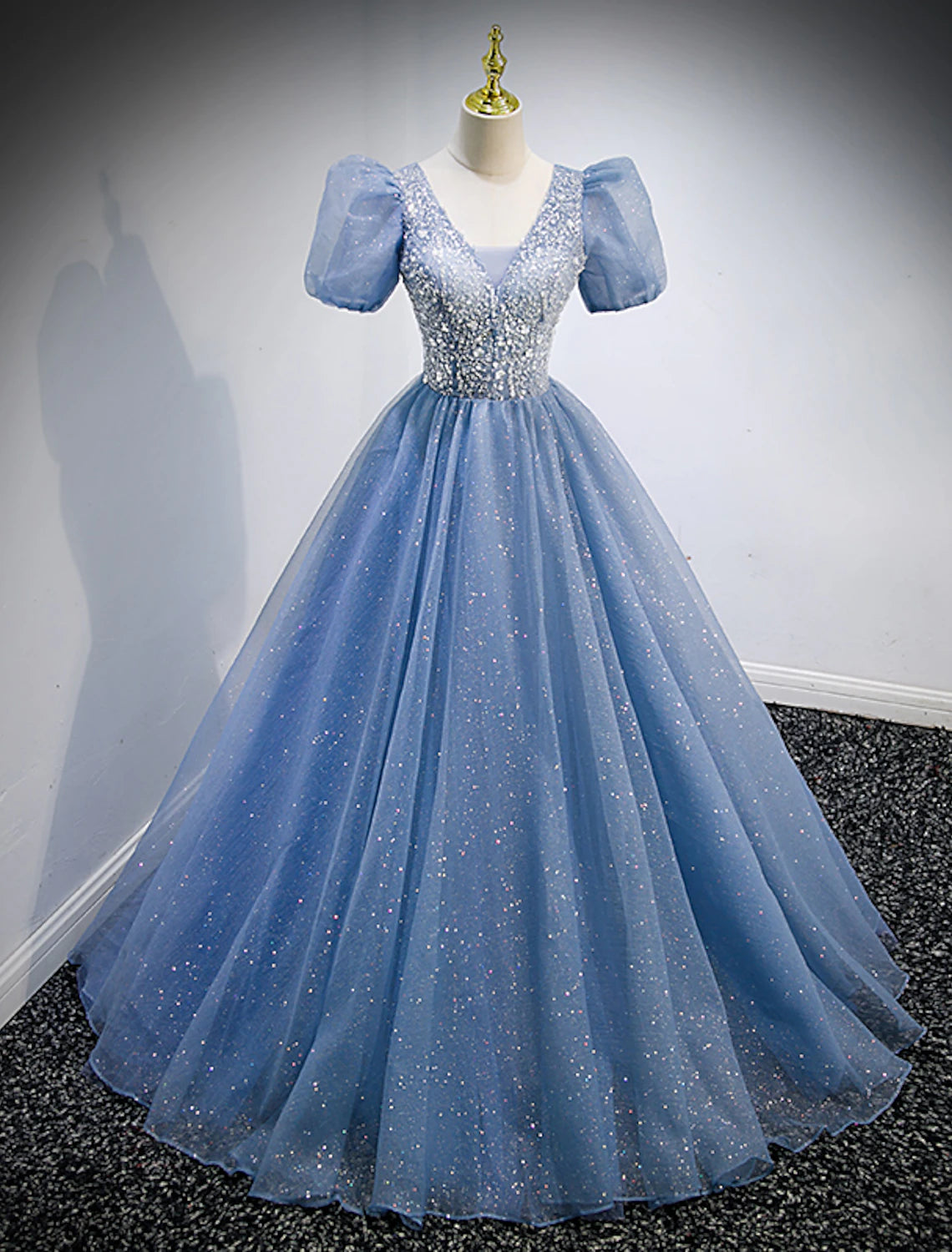 Model wearing a sparkling A-line V-neck short sleeve sequin tulle floor length quinceanera dress.