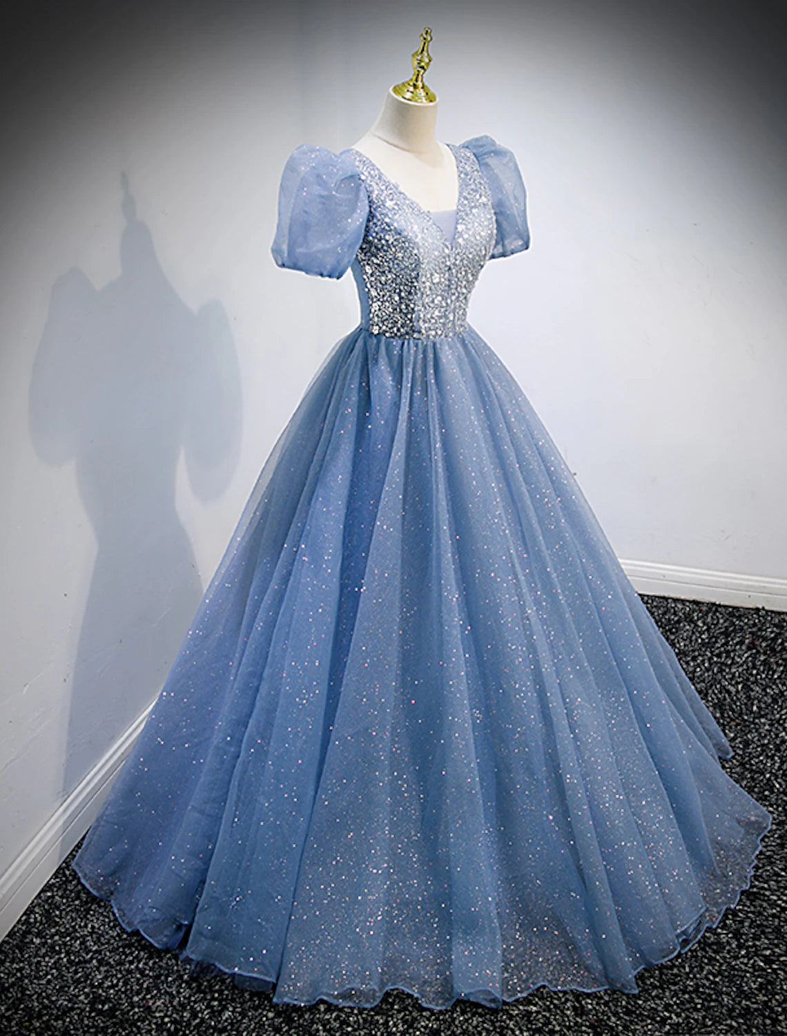 Detail of the V-neckline and short sleeves on the sequin tulle formal dress.