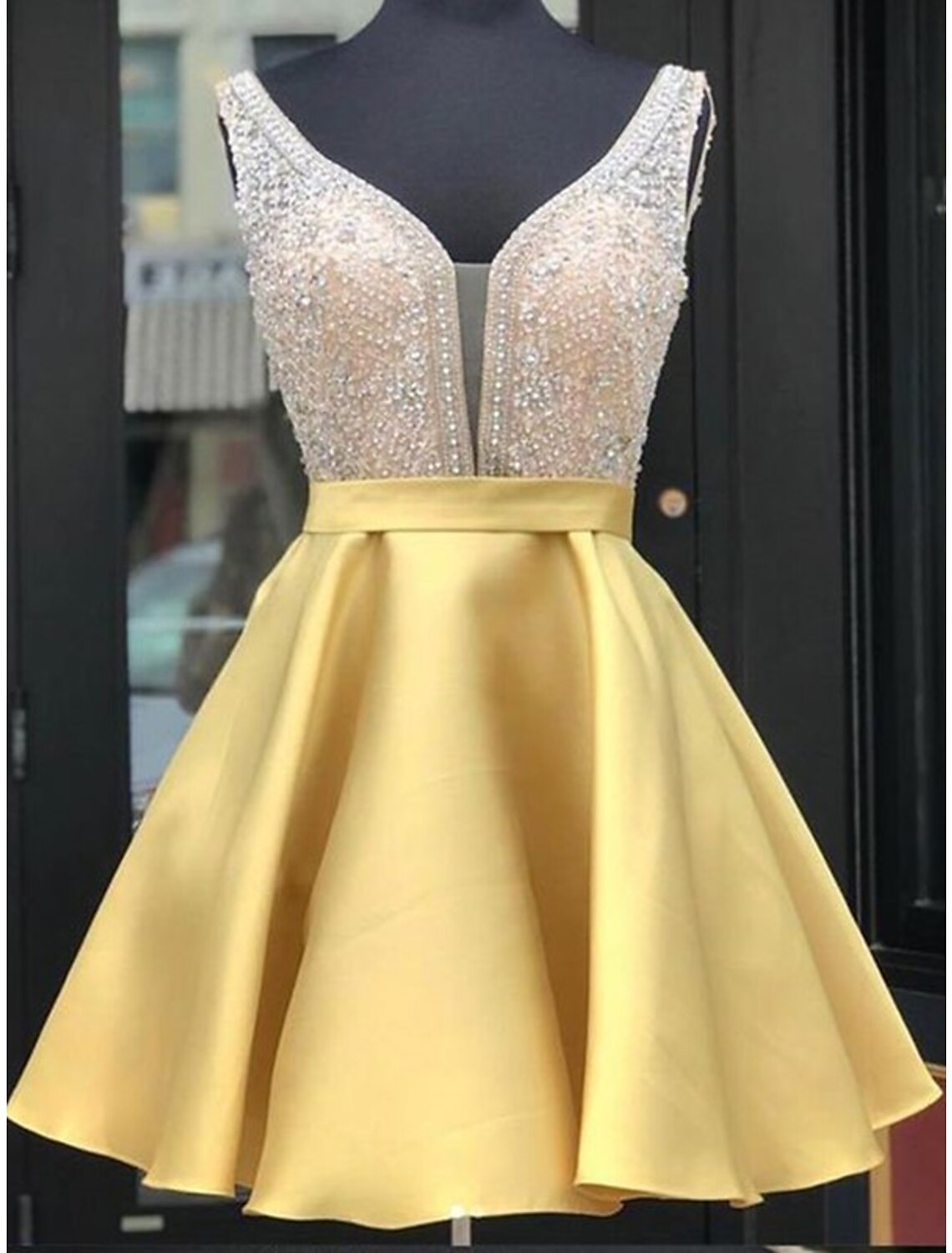 Sparkling A-line V-neck sleeveless homecoming dress with beading on satin fabric.