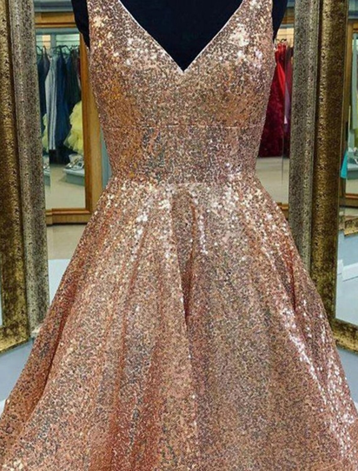 Side view of a model in a sparkling A-line V-neck sequined tea-length dress.