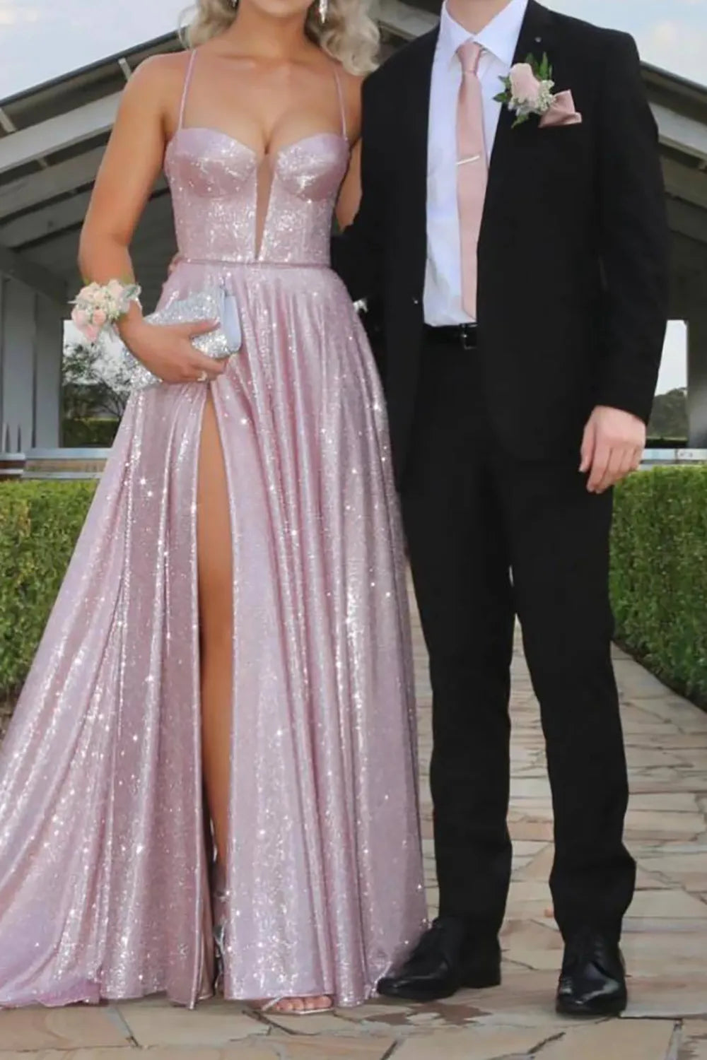 Model wearing a sparkling A-line long prom dress with spaghetti straps and a high front slit.