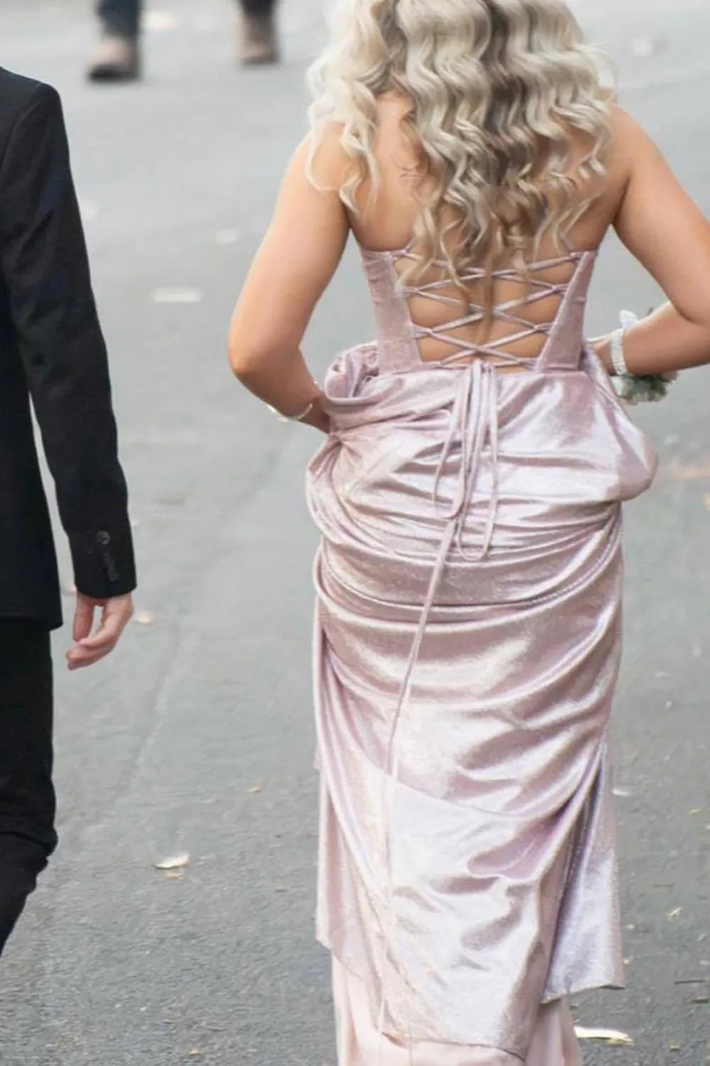 Woman posing in a sparkling A-line prom dress, showcasing the elegant silhouette and high slit.