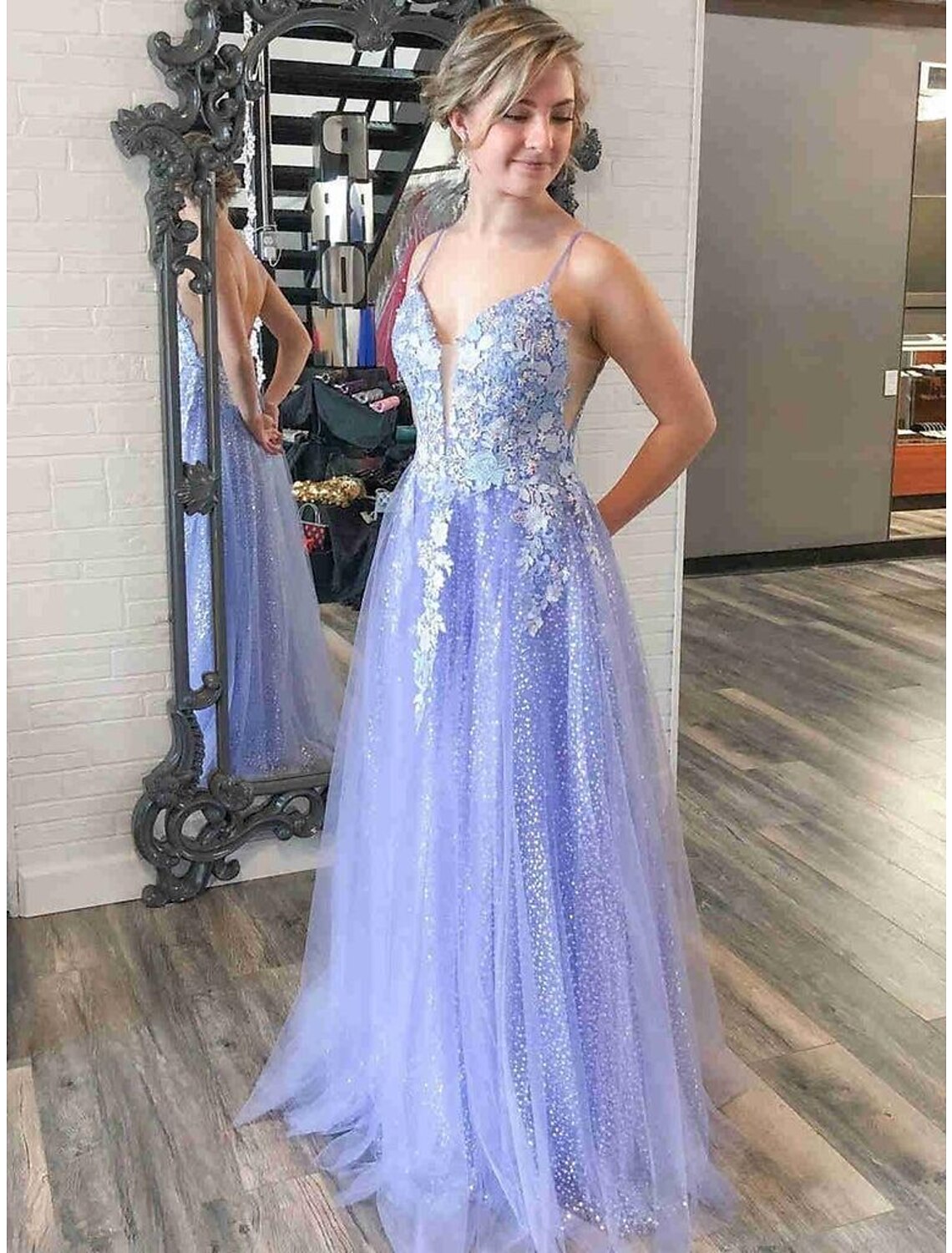 Model wearing a sparkling A-line V-neck prom dress with sequin appliques and a floor-length tulle skirt.