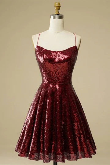 Model wearing a sparkling A-line sequin mini homecoming dress with a V-neck and lace-up back.