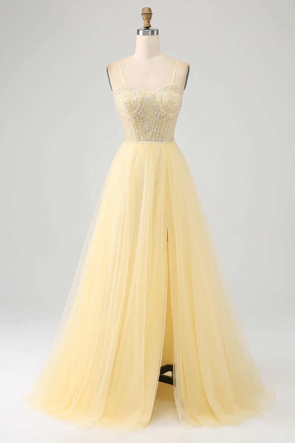 Light yellow tulle prom dress with beading and a high slit, front view.