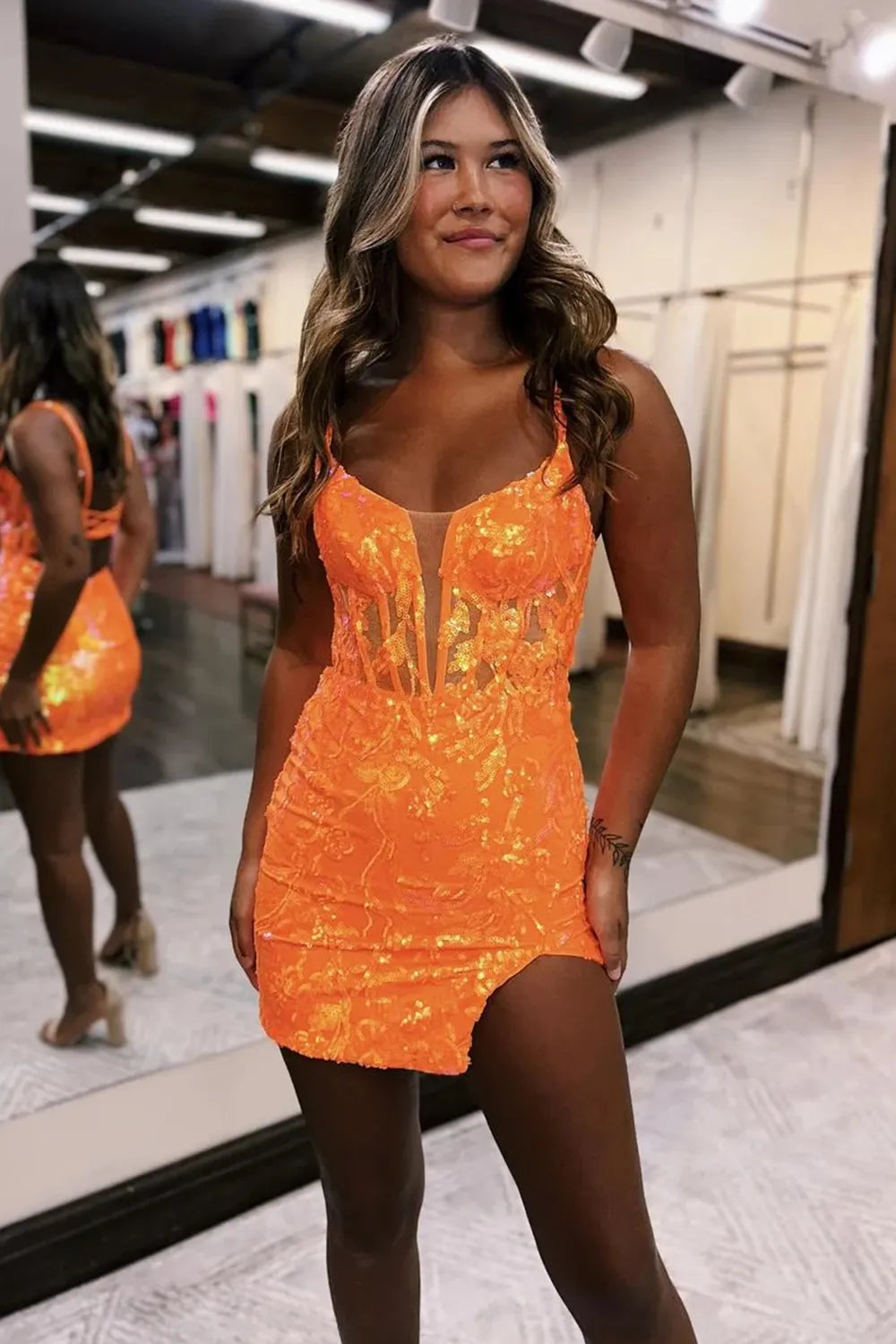 Model showcasing an orange bodycon sequin party dress.