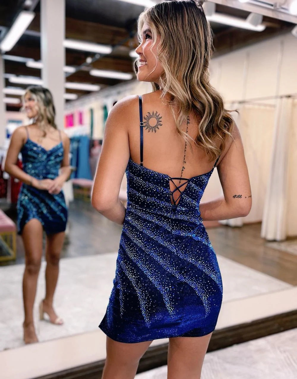 Woman smiling in a shimmering spaghetti strap bodycon dress.