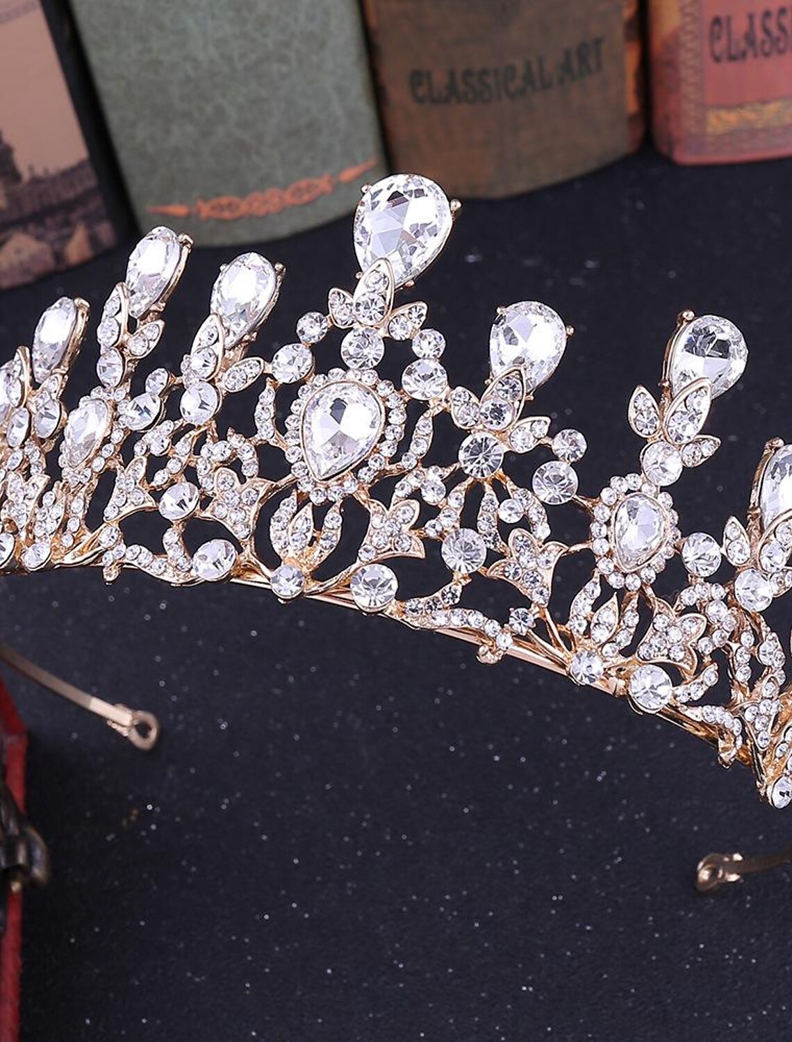Side view of an ornate crystal queen tiara on a model.