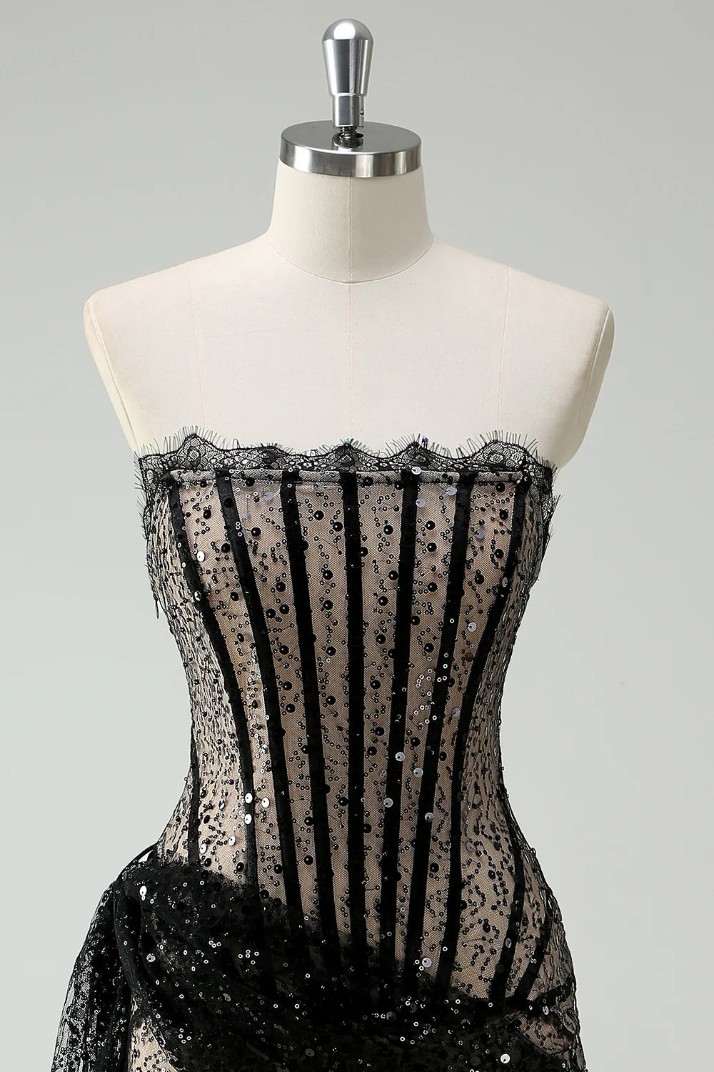 Close-up of the glitter fabric and lace corset detail on the dress.
