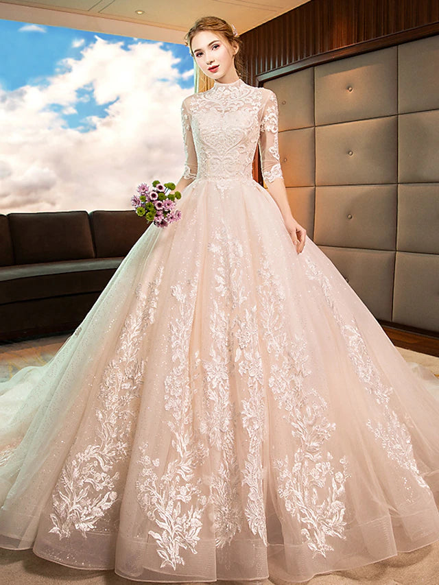 Full view of sparkling white high-neck long-sleeve lace ball gown wedding dress with cathedral train.