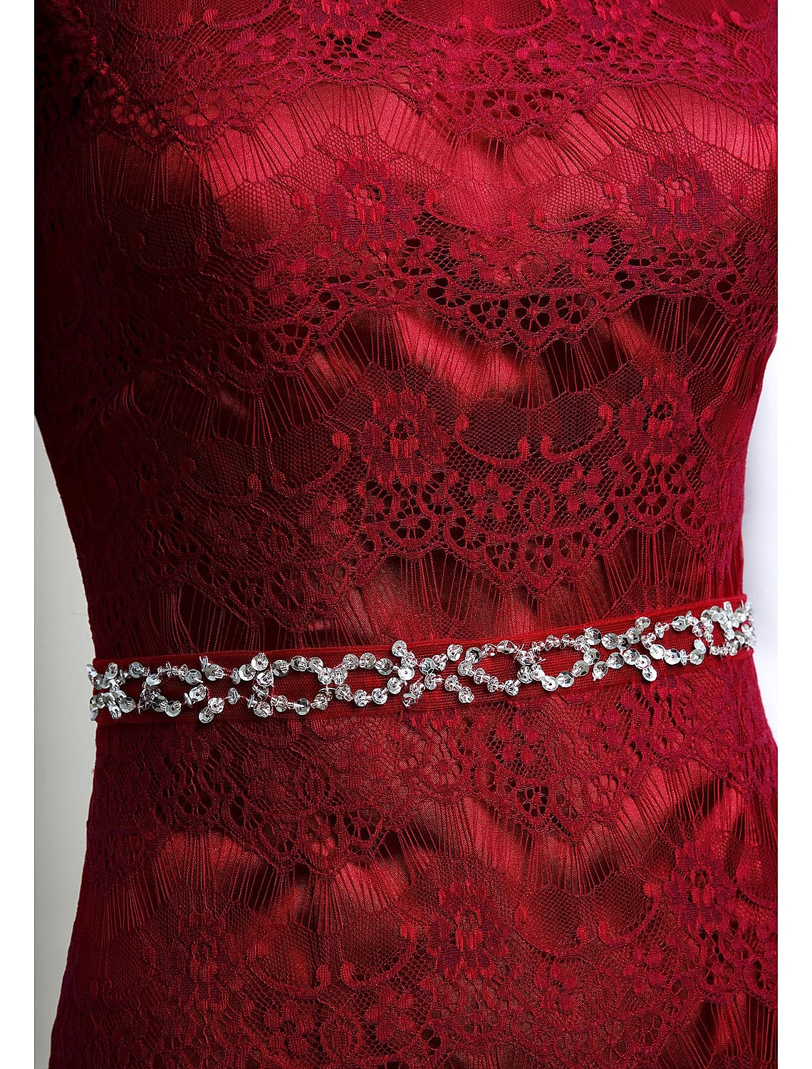 Detail of the jewel neckline and lace overlay on the formal gown.