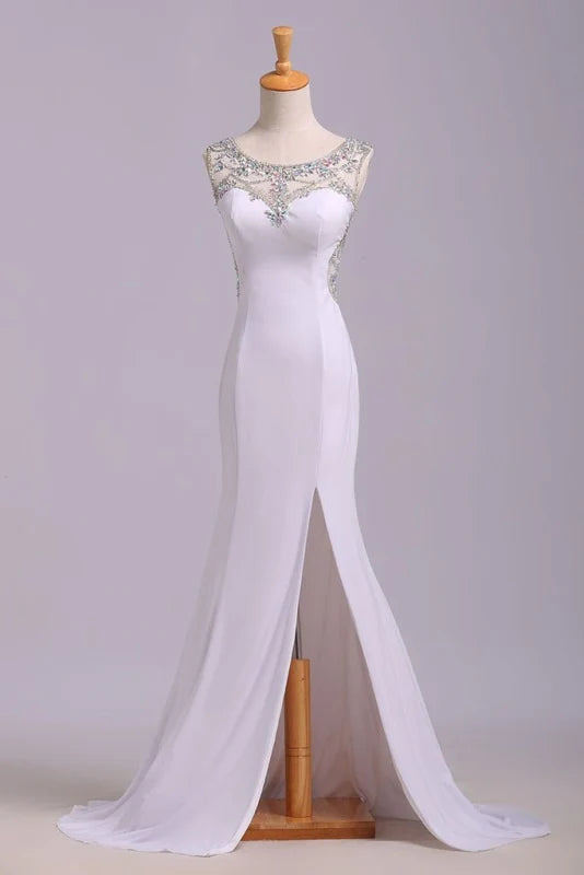 Woman wearing a sparkling mermaid sequined prom dress with a plunging neckline and high slit.