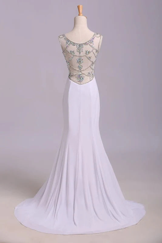 Back view of a woman in a sequined mermaid prom dress with a sweep train.
