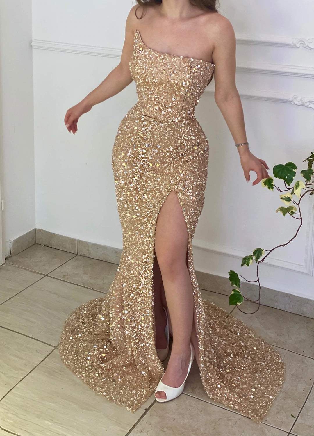 Gold sequin mermaid prom dress with strapless neckline and high split.