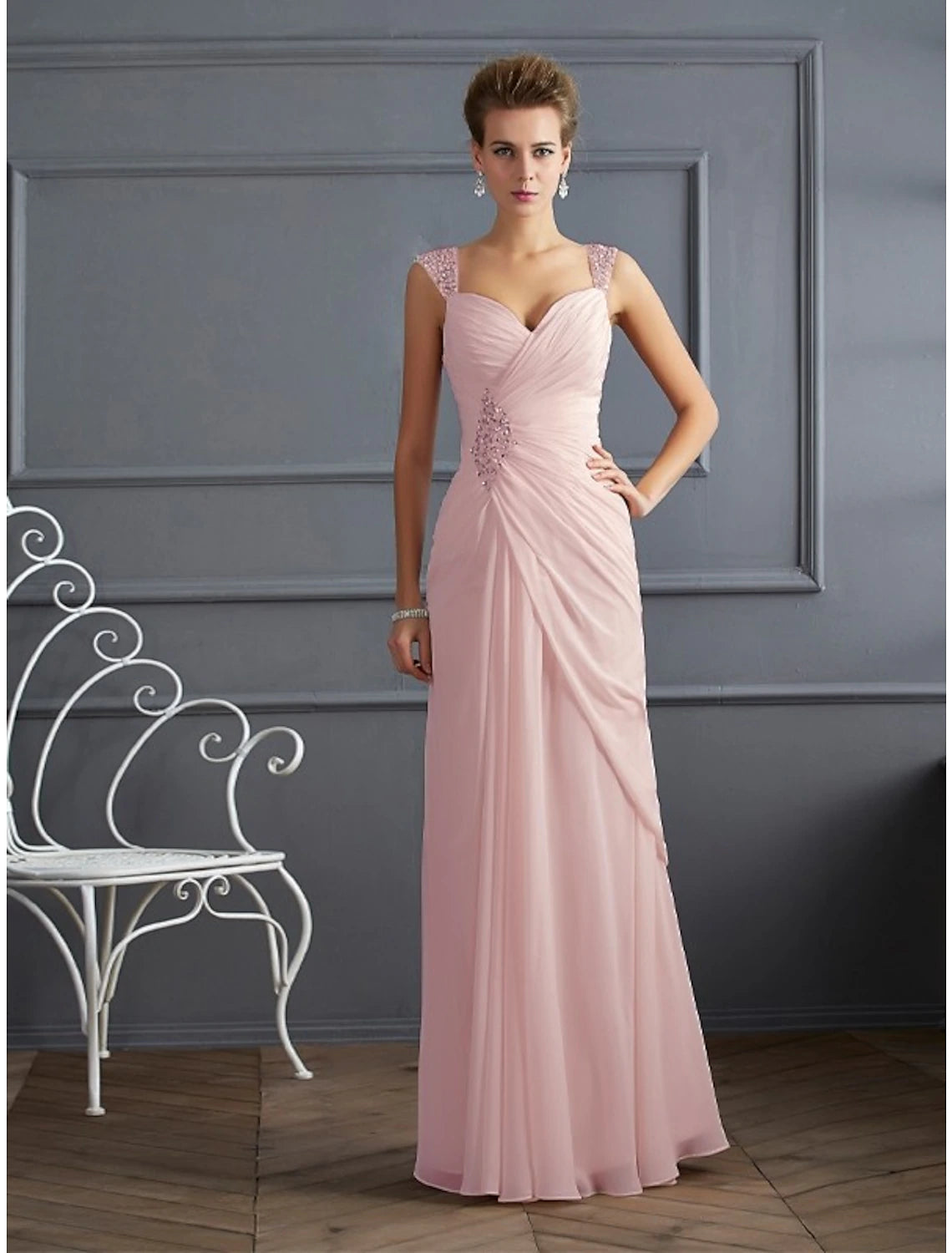 Woman wearing a sparkling silver mermaid trumpet evening gown with spaghetti straps.