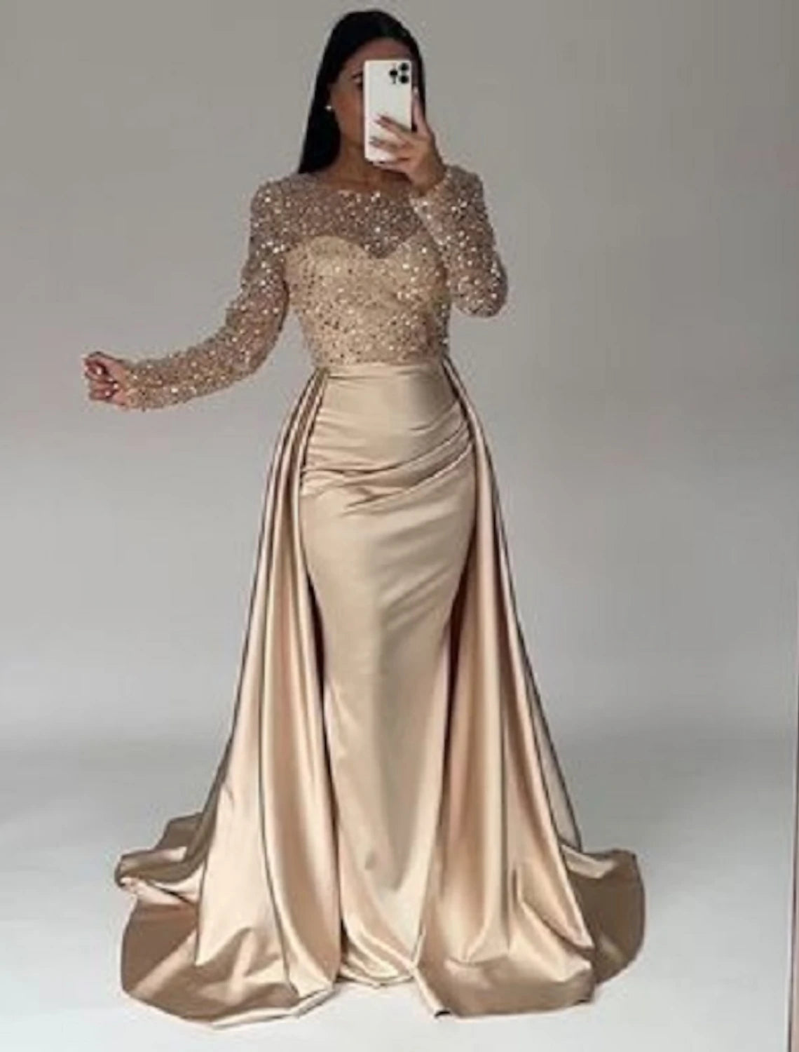 Full view of a sparkling mermaid trumpet evening gown with long illusion sleeves.