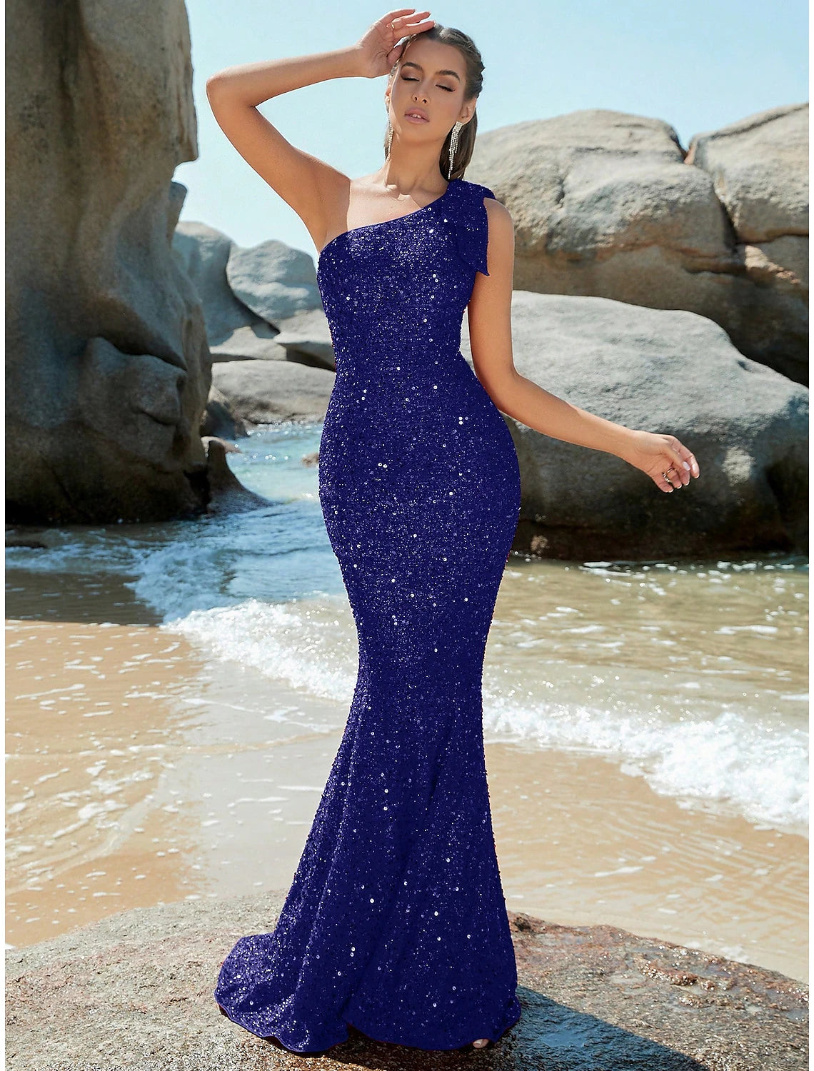 Silver sequined mermaid trumpet evening gown with one shoulder and sweep train.