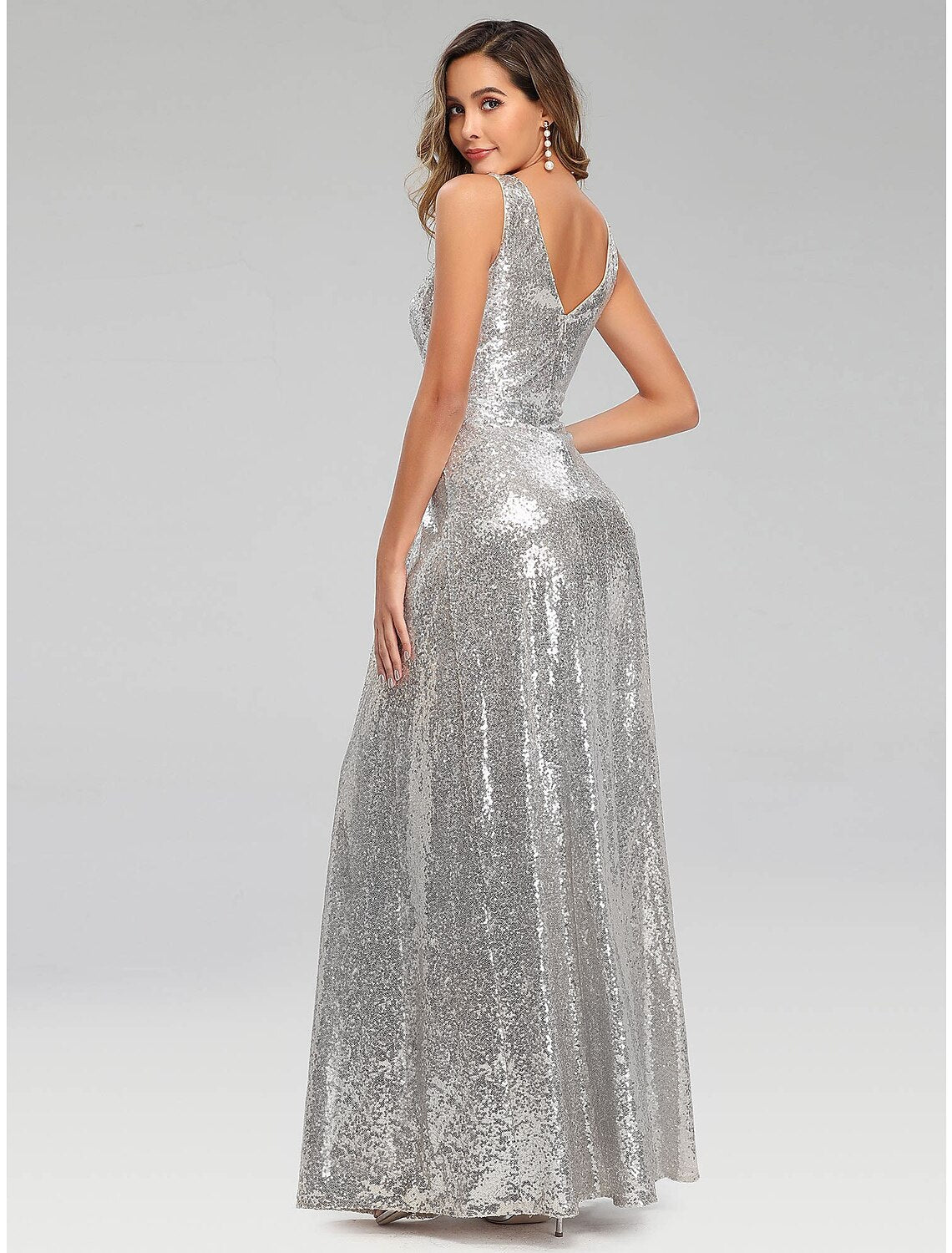 Back view of a woman wearing a V-back sequin evening dress.