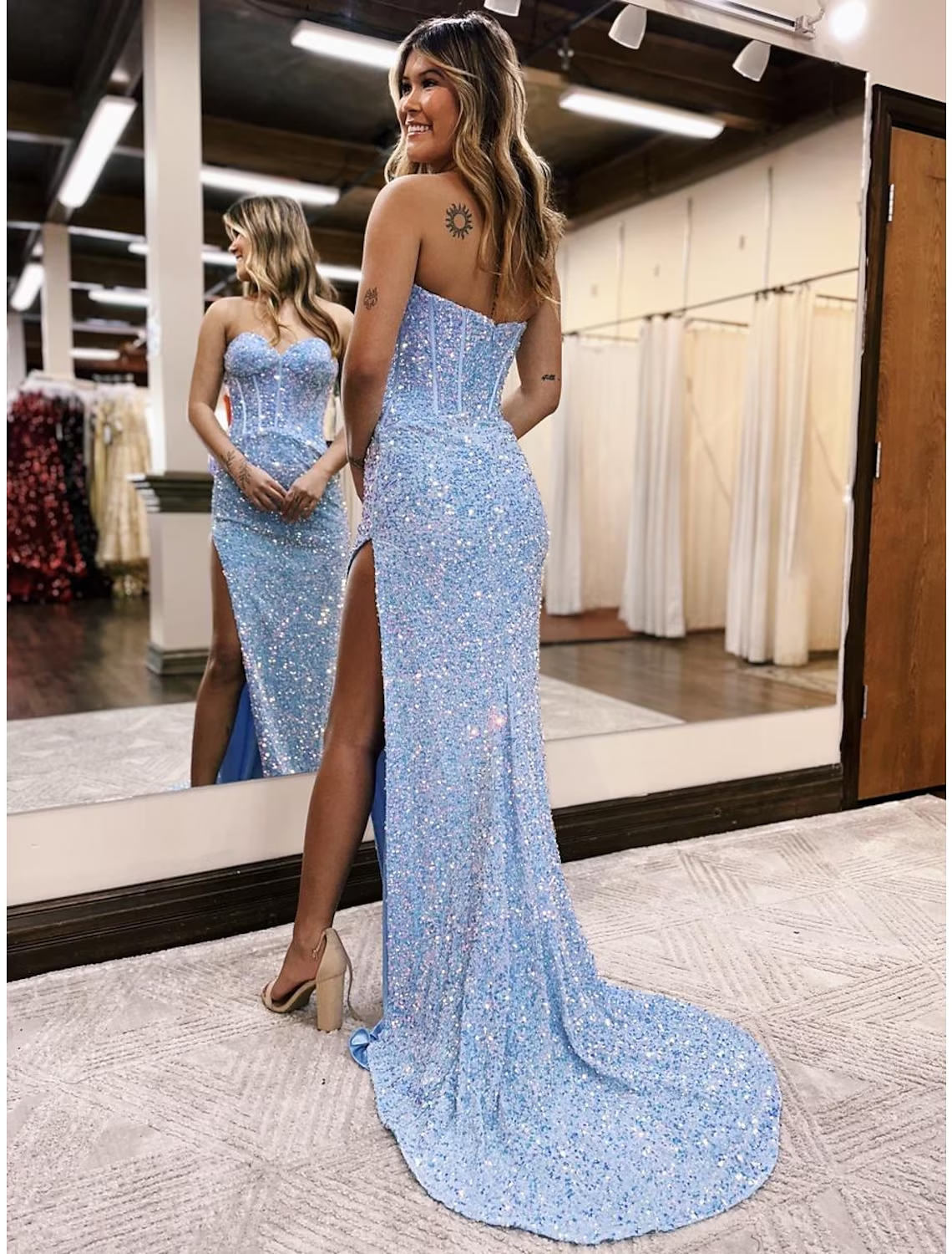 Back view of the navy blue sequined mermaid prom dress, highlighting its elegant backless design and court train.