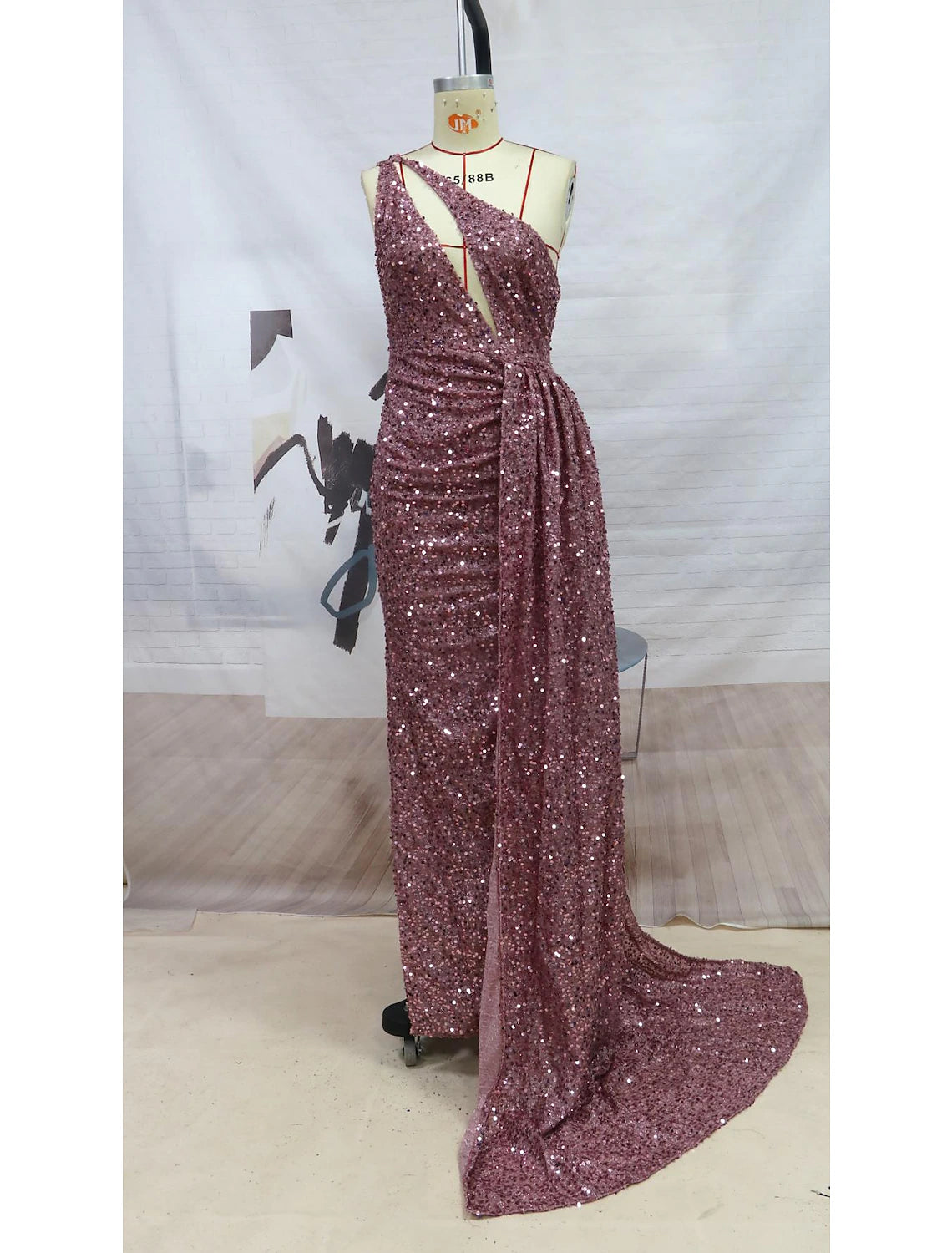 Back view of a sequined one-shoulder formal gown with a court train.