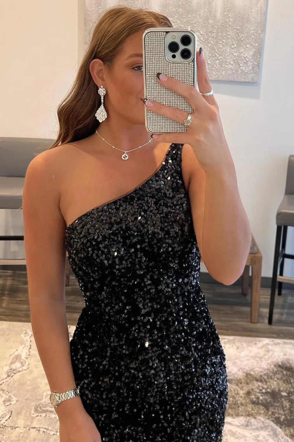 Side profile of a woman in a glittering one-shoulder party dress.