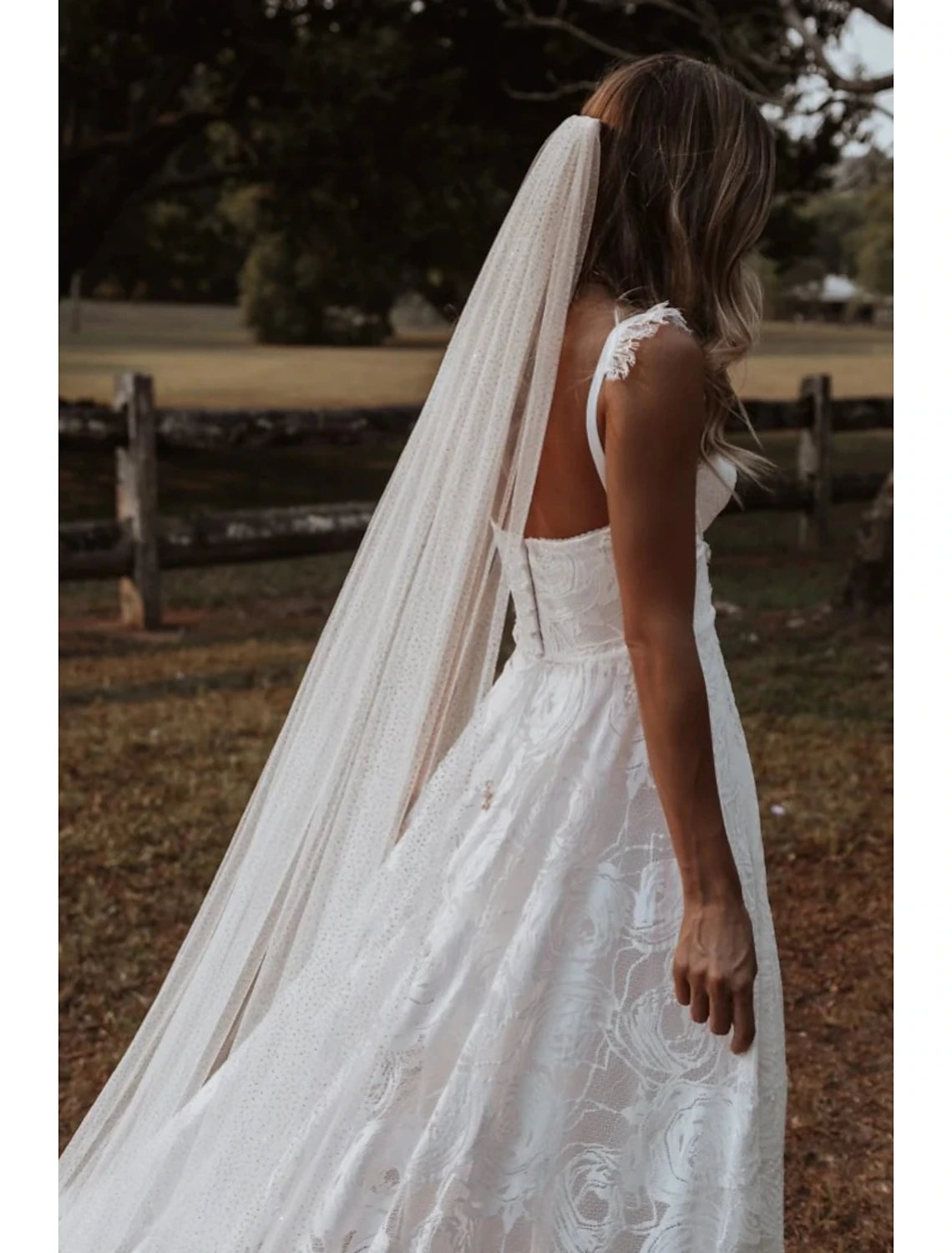 Bride wearing a sparkling one-tier cathedral wedding veil with sequins.