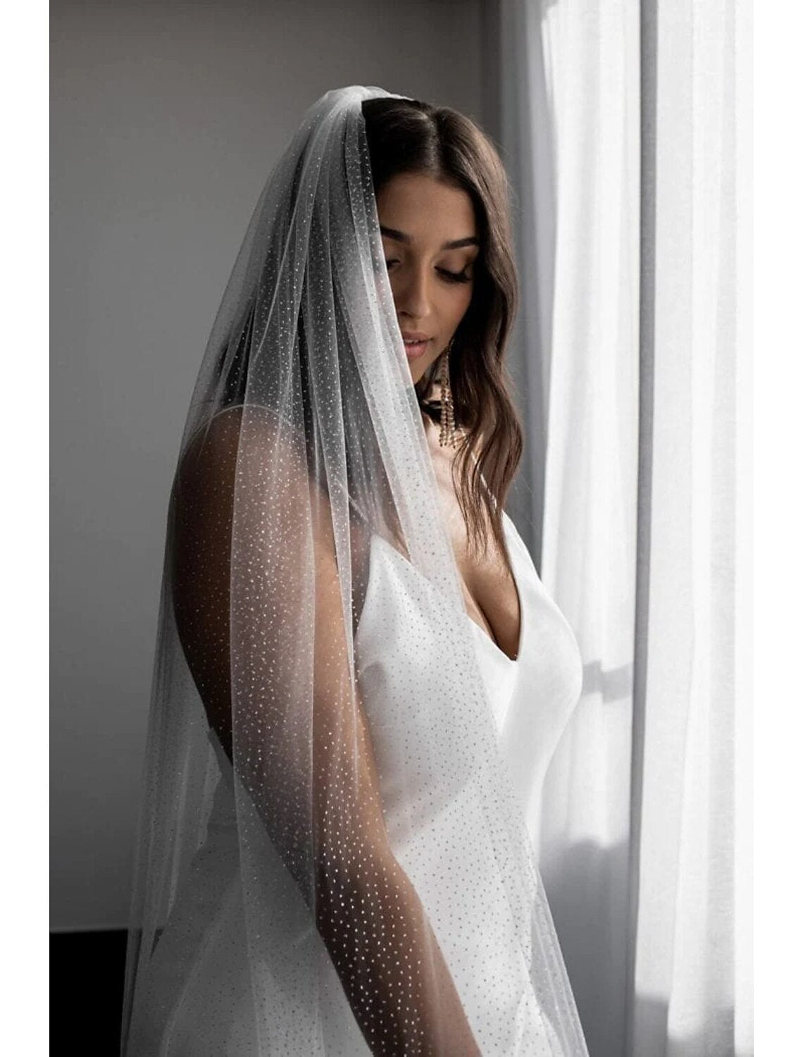 Back view of a bride with a shimmering one-tier wedding veil.