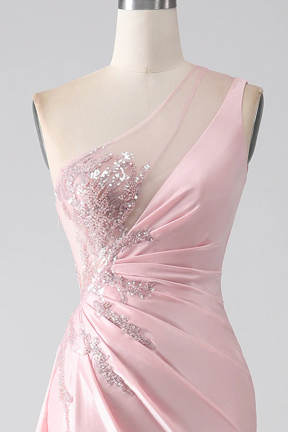 Full length view of a pink sequined one-shoulder prom dress.