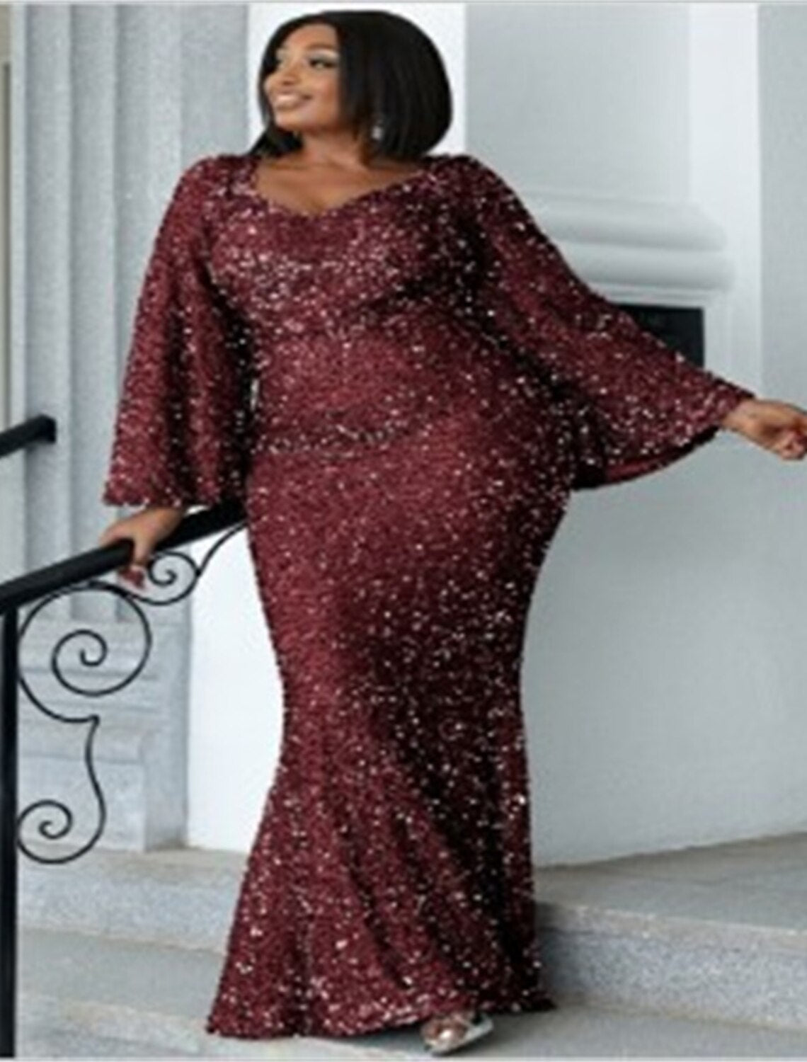 Model wearing a floor-length sequined mermaid dress, suitable for black tie.