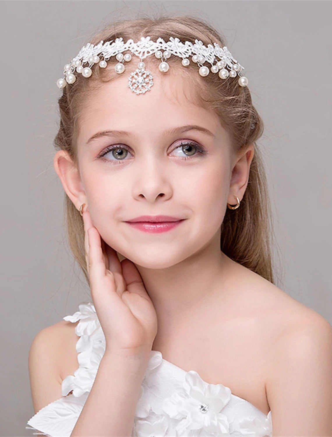 Young girl wearing a sparkling princess tiara head chain with delicate floral accents.