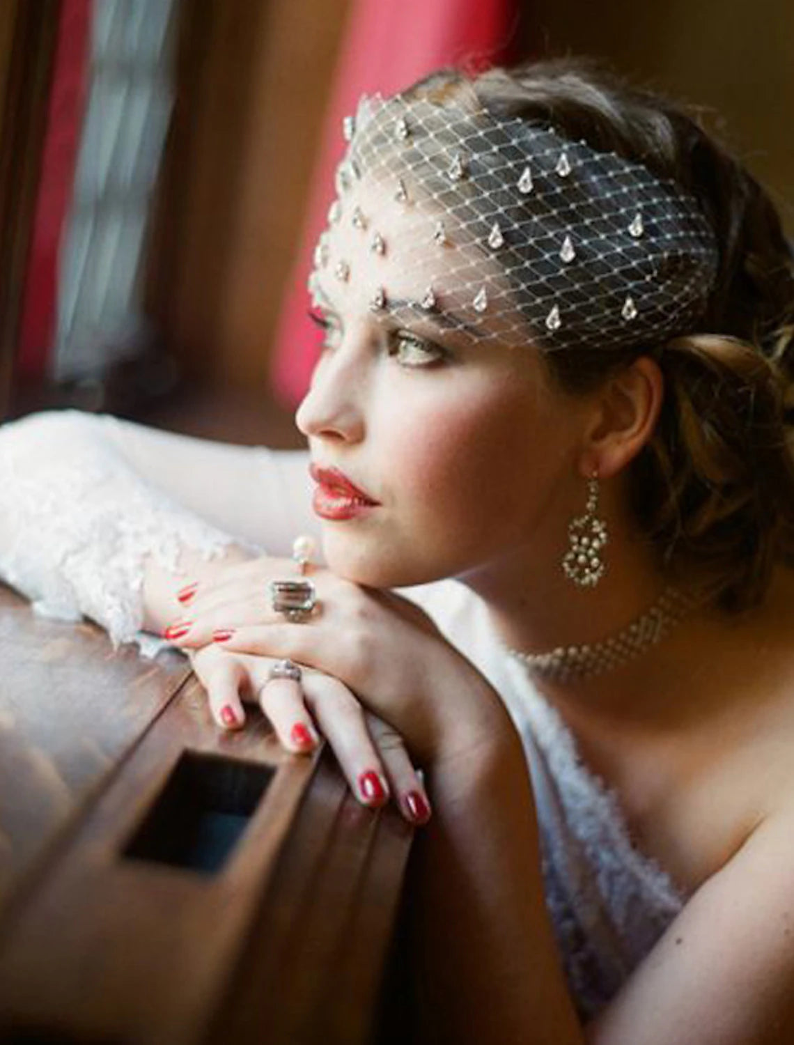 Side view of a bride wearing a one-tier wedding veil with sparkling accents.