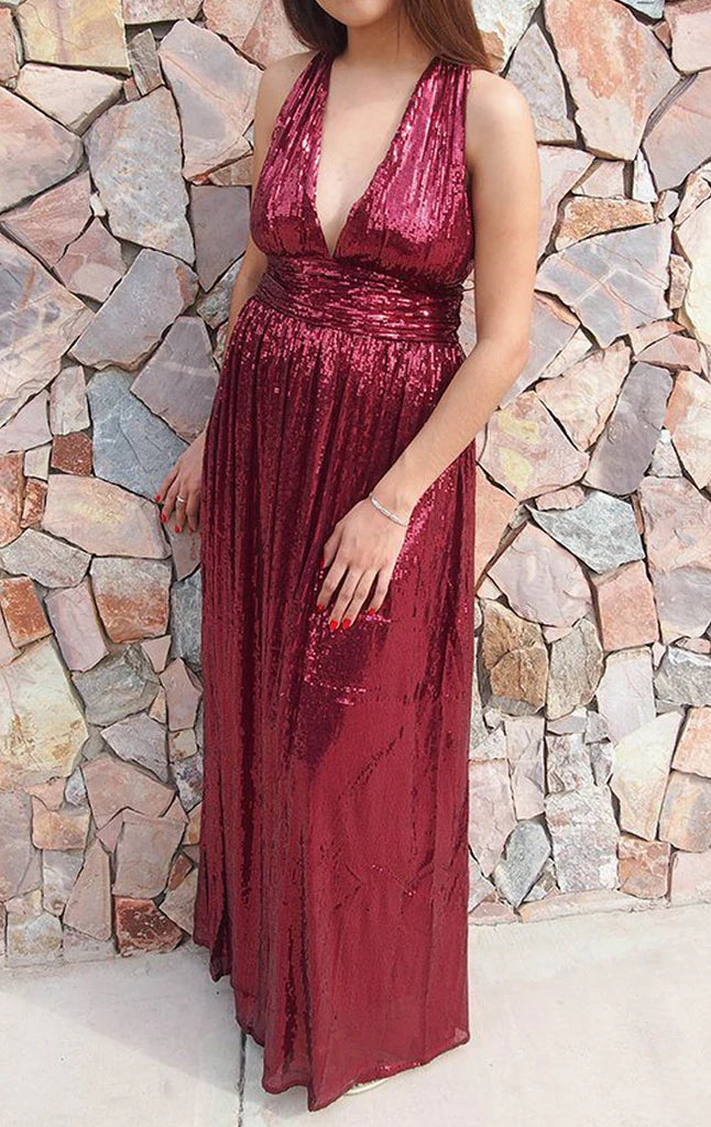 Woman wearing a sparkling sequin deep V-neck maxi formal gown.