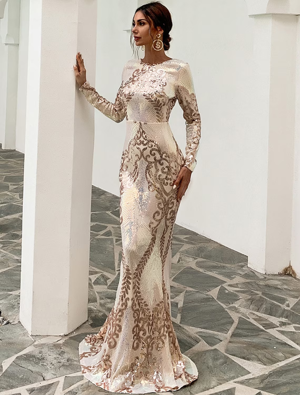 Back view of a woman in a sequin mermaid gown, highlighting the backless design.