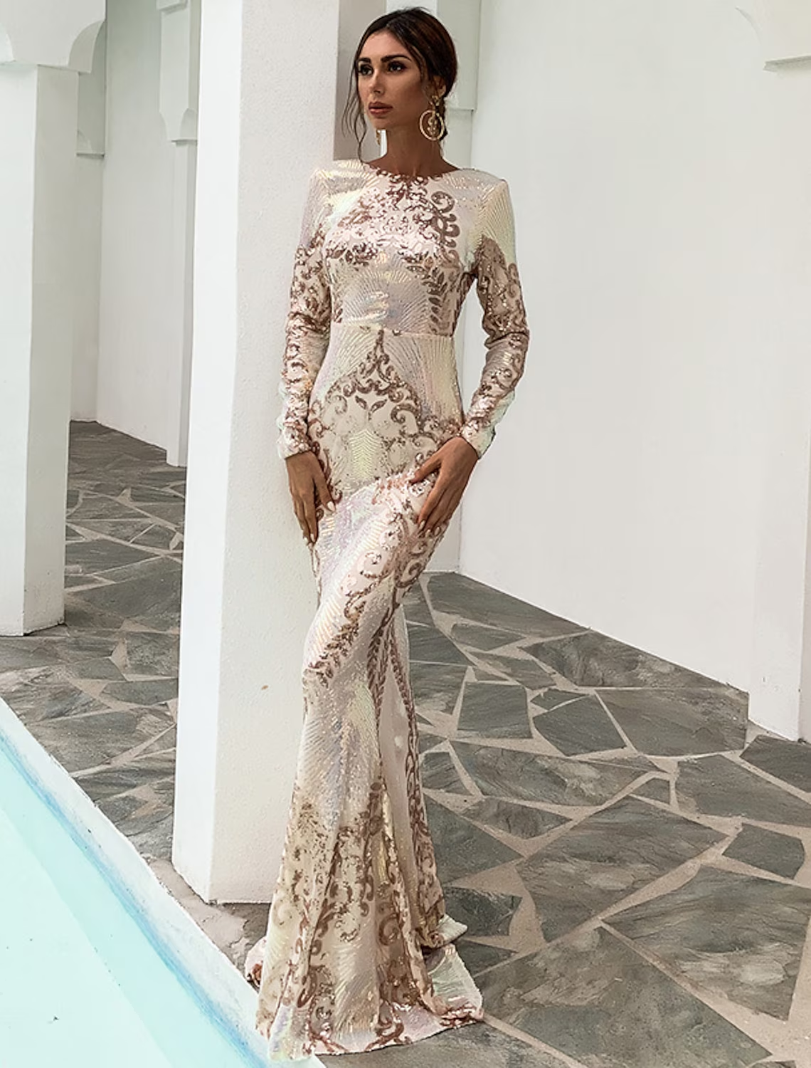 Side profile of a woman in a long sleeve sequin mermaid dress.