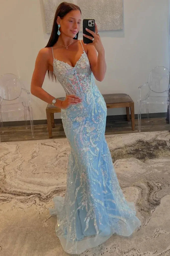 Full length view of a woman wearing a sparkling sequin mermaid prom dress with spaghetti straps.