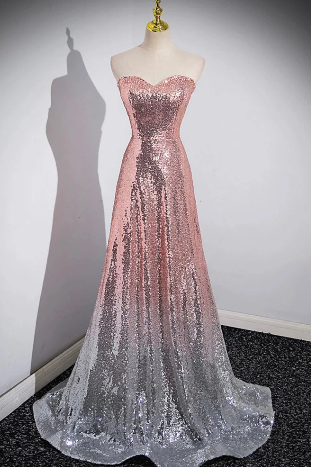 Woman wearing a sparkling blue mermaid prom dress with a sweetheart neckline.