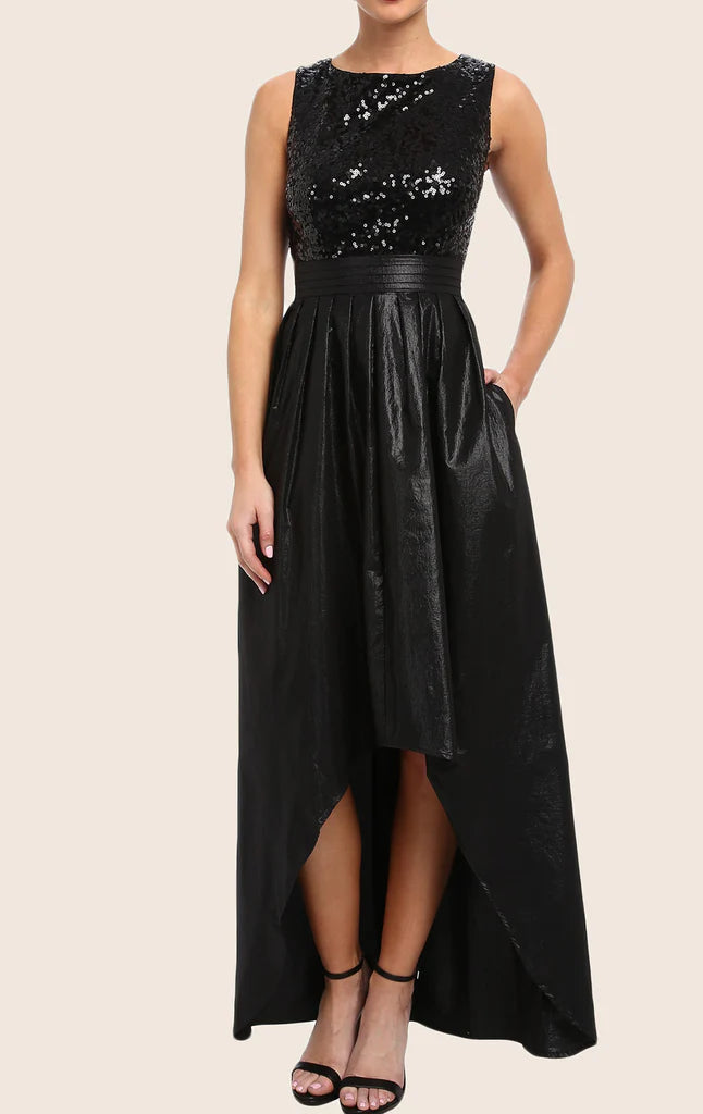 A woman wearing a sparkling sequin high-low prom gown with spaghetti straps and a V-neck.