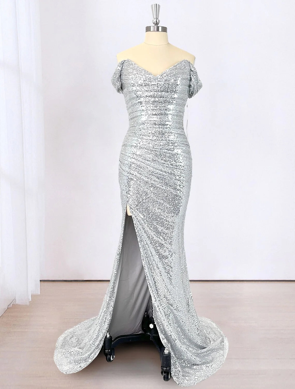 Woman wearing a sparkling sequined mermaid evening gown with off-shoulder neckline, front view.