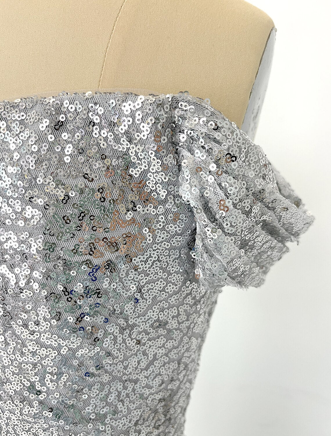 Close-up of the ruched detailing and sequin embellishments on the mermaid gown.