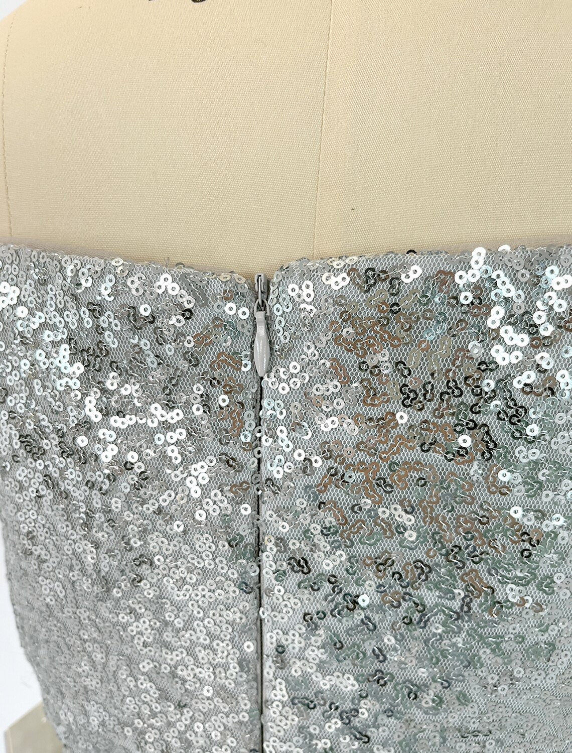 Woman elegantly posing in the sparkling sequined off-shoulder mermaid gown.