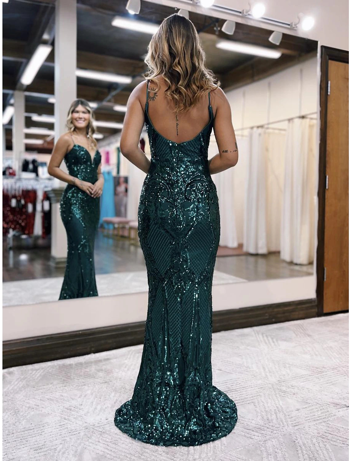Full length view of a sparkling sequined mermaid prom dress with a sweep train.