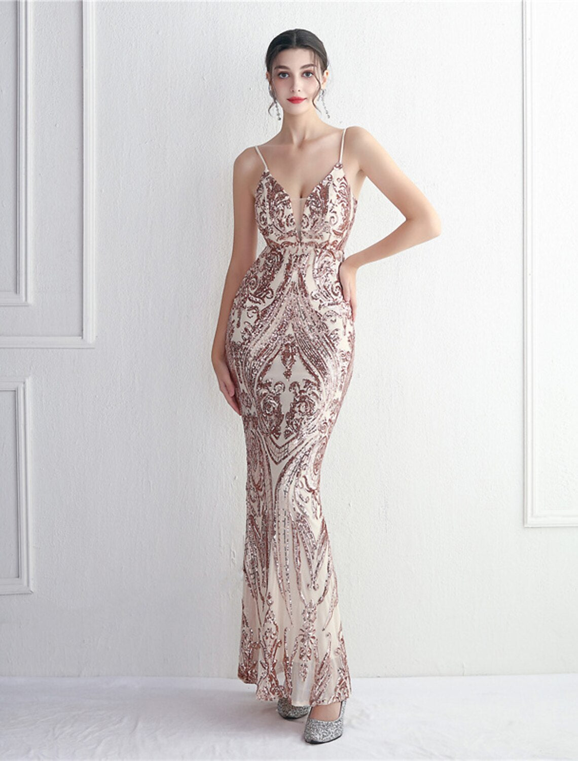 Side profile of a woman wearing a floor-length sequined gown.