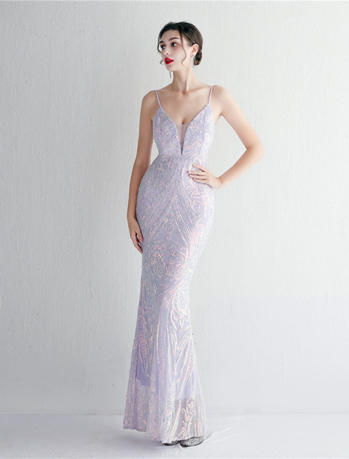 Woman showcasing the flowing train of the sequined gown.