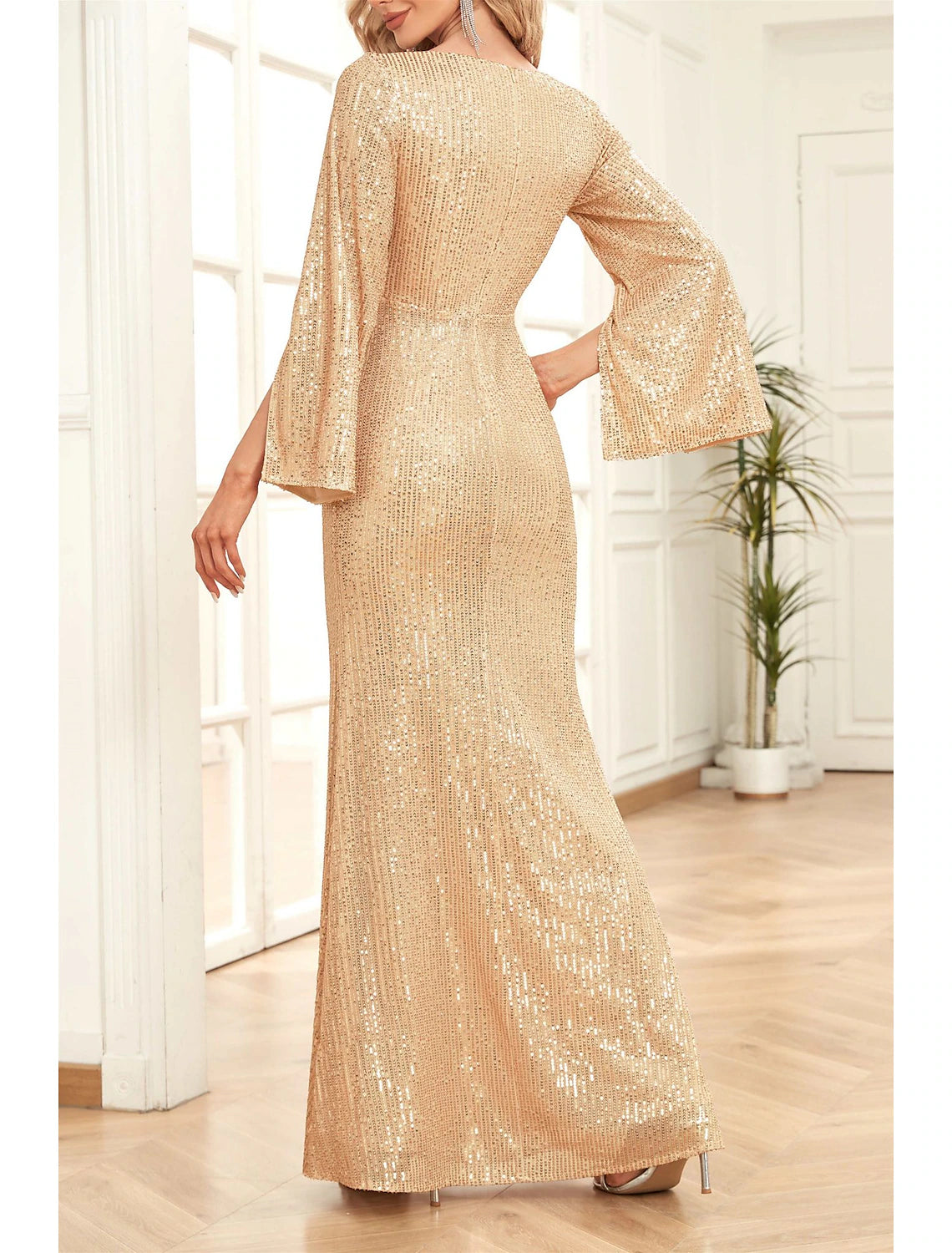 Back view of a woman in a floor-length sequined mermaid trumpet gown.