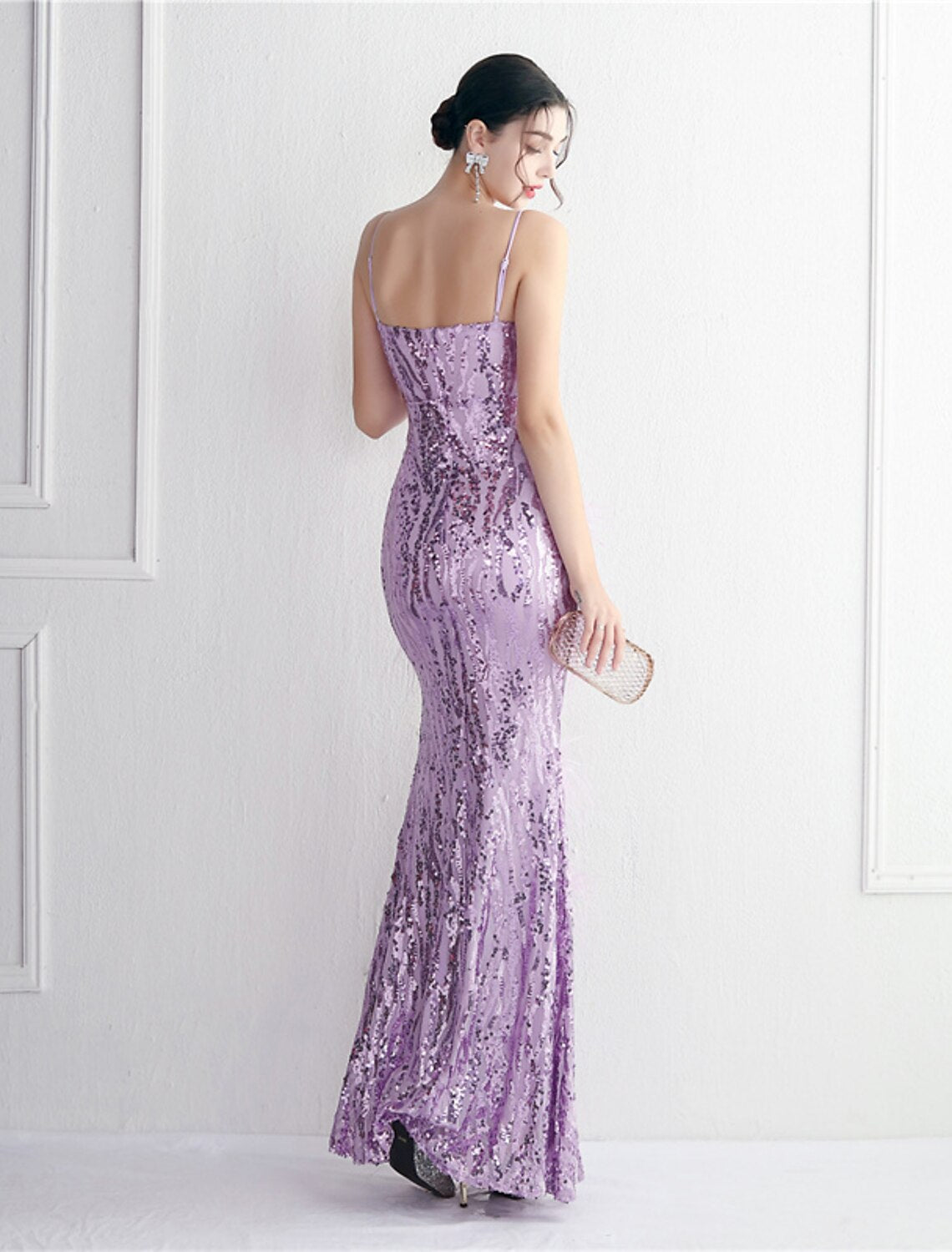 Side view of a model showcasing the elegant silhouette of the sequined formal dress.